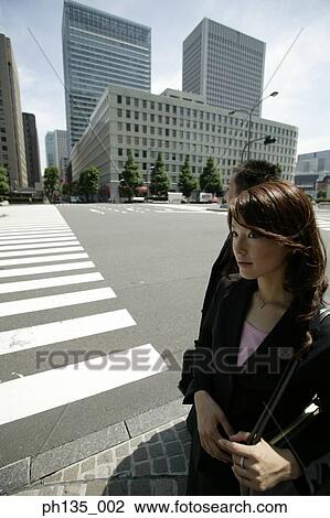 Young business executives waiting on a sidewalk View Large Photo Image Stock Image - Young business executives waiting on a sidewalk. Fotosearch