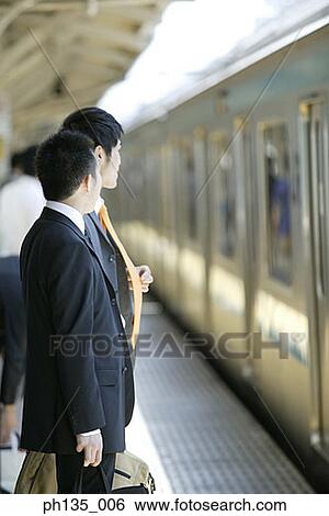 Young businessmen waiting at a train station View Large Photo Image Stock Photograph - Young businessmen waiting at a train station. Fotosearch