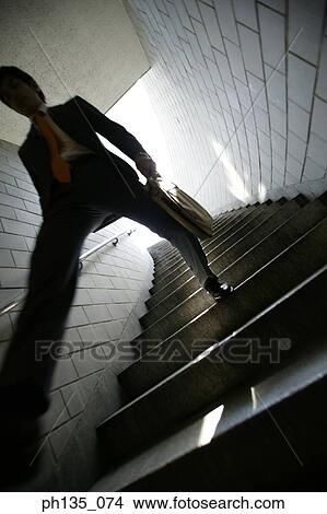 Low angle view of a young businessman coming down a flight of stairs View Large Photo Image Picture - Low angle view of a young businessman coming down a flight of stairs. Fotosearch