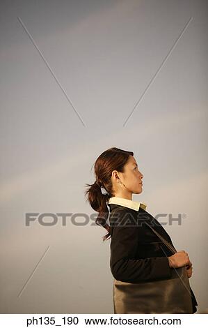 Side profile of a young businesswoman carrying a shoulder bag View Large Photo Image Stock Image - Side profile of a young businesswoman carrying a shoulder bag. Fotosearch