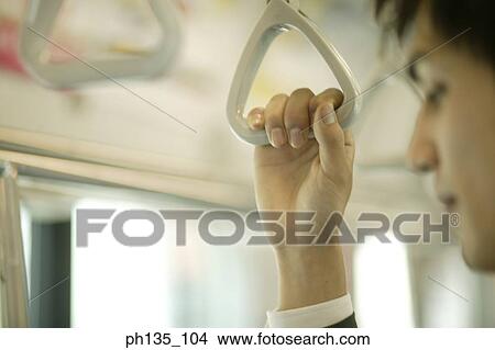Picture - Young businessman holding a safety handle. Fotosearch
