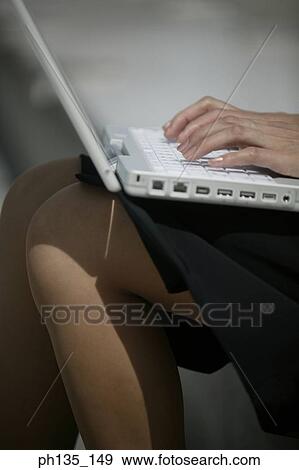 Stock Photo - Young businesswoman sitting operating a laptop computer. Fotosearch