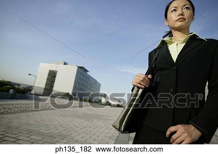 Young businesswoman standing with a shoulder bag View Large Photo Image Stock Image - Young businesswoman standing with a shoulder bag. Fotosearch