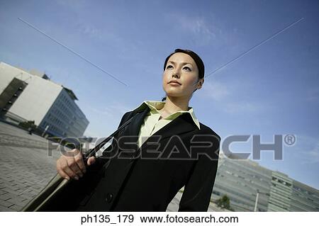 Young businesswoman standing with a shoulder bag View Large Photo Image Stock Photo - Young businesswoman standing with a shoulder bag. Fotosearch