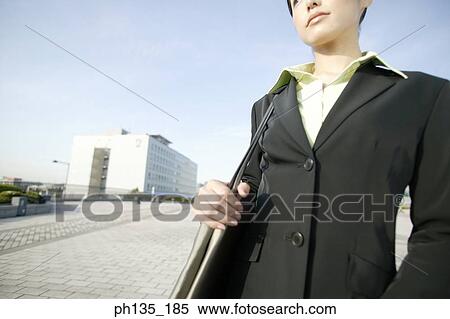 Young businesswoman standing with a shoulder bag View Large Photo Image Stock Photography - Young businesswoman standing with a shoulder bag. Fotosearch
