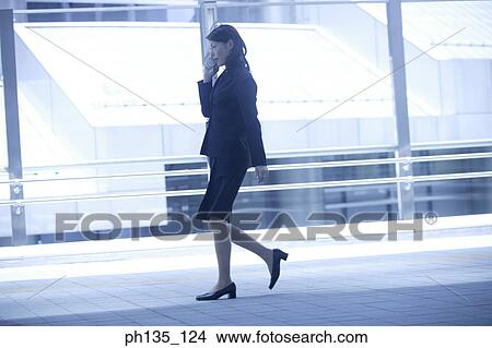 Young businesswoman talking on a mobile phone View Large Photo Image Picture - Young businesswoman talking on a mobile phone. Fotosearch