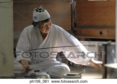 Blacksmith working on a sword in a workshop View Large Photo Image Stock Image - Blacksmith working on a sword in a workshop. Fotosearch