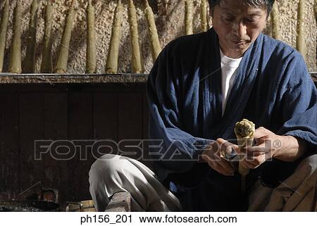 Stock Image - Close-up of a mid adult man shaping a candle. Fotosearch