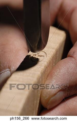 Close-up of a person's hand holding a wooden piece View Large Photo Image Stock Photograph - Close-up of a person's hand holding a wooden piece. Fotosearch