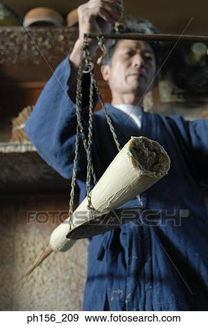 Low angle view of a mid adult man weighing a candle on a weighing scale View Large Photo Image Stock Photo - Low angle view of a mid adult man weighing a candle on a weighing scale. Fotosearch