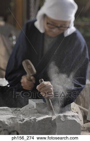 Sculptor carving a stone with a chisel and a hammer View Large Photo Image Picture - Sculptor carving a stone with a chisel and a hammer. Fotosearch