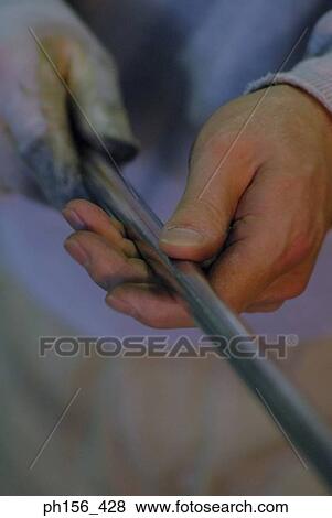 Close-up of a human hands holding an iron rod View Large Photo Image Stock Photo - Close-up of a human hands holding an iron rod. Fotosearch