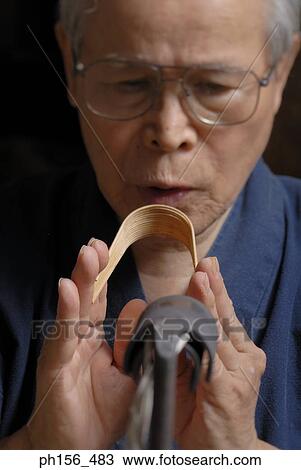 Stock Image - Close-up of a man molding wooden stick. Fotosearch