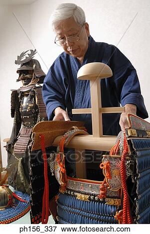 Close-up of a person adjusting a traditional costume on a wooden stand View Large Photo Image Stock Photo - Close-up of a person adjusting a traditional costume on a wooden stand. Fotosearch