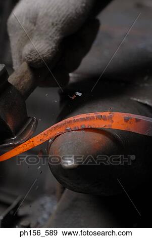 Stock Photo - Close-up of a person's hand bending a molten rod. Fotosearch