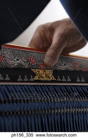 Stock Photography - Close-up of a person's hand holding a traditional costume. Fotosearch