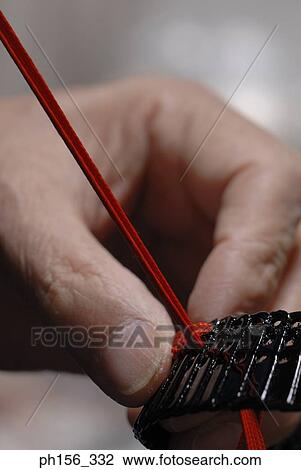 Close-up of a person's hand weaving strap with a ribbon View Large Photo Image Stock Image - Close-up of a person's hand weaving strap with a ribbon. Fotosearch