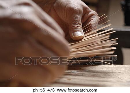 Stock Image - Close-up of a person's hands making a basket. Fotosearch