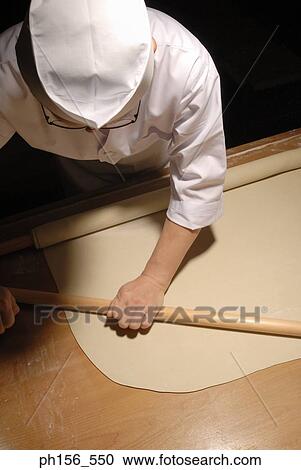 Stock Image - High angle view of a chef rolling dough. Fotosearch