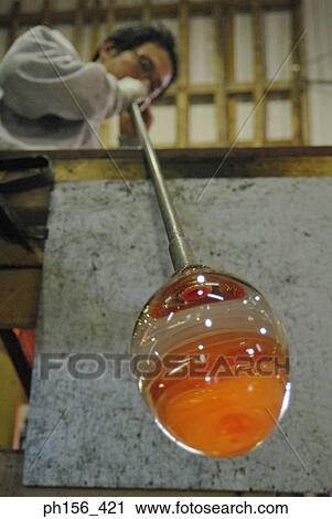 Low angle view of a mid adult man blowing molten glass with a blow pipe View Large Photo Image Stock Image - Low angle view of a mid adult man blowing molten glass with a blow pipe. Fotosearch