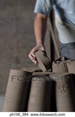 Picture - Mid section view of a person holding a piece of clay. Fotosearch