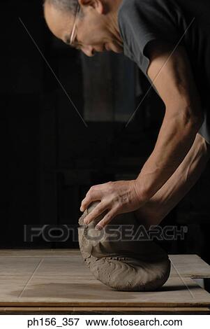 Side profile of a potter kneading clay View Large Photo Image Stock Photo - Side profile of a potter kneading clay. Fotosearch
