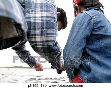 Stock Image - Boy and his father at the riverside. Fotosearch
