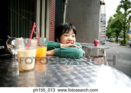 Close-up of a boy leaning on a table and smiling View Large Photo Image Stock Image - Close-up of a boy leaning on a table and smiling. Fotosearch
