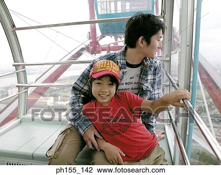 Close-up of a father and son sitting together in a trolley View Large Photo Image Stock Image - Close-up of a father and son sitting together in a trolley. Fotosearch