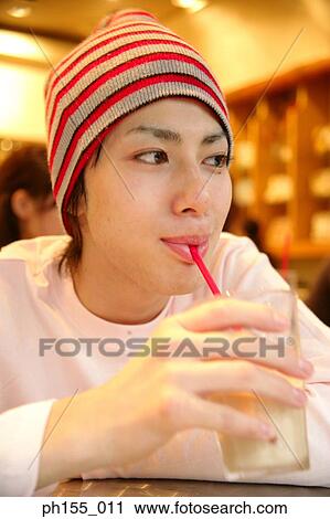 Close-up of a young man sipping cold coffee View Large Photo Image Stock Image - Close-up of a young man sipping cold coffee. Fotosearch