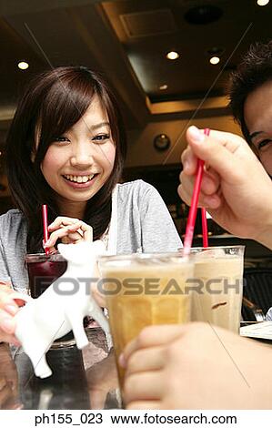 Stock Image - Close-up of a young woman holding a glass of coffee. Fotosearch