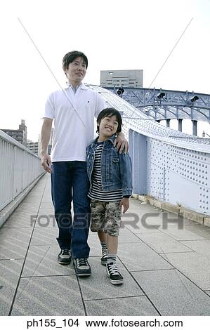 Father and his son walking on a bridge View Large Photo Image Picture - Father and his son walking on a bridge. Fotosearch