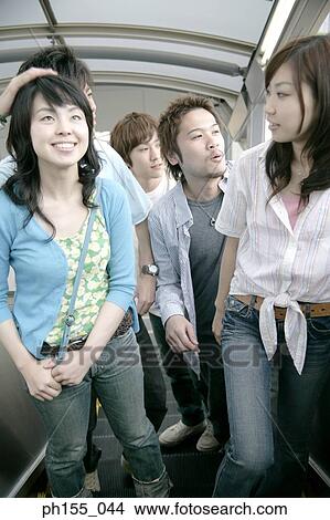 Five people standing on an escalator View Large Photo Image Picture - Five people standing on an escalator. Fotosearch