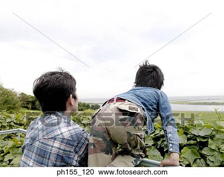 Rear view of a man and his son standing together View Large Photo Image Stock Image - Rear view of a man and his son standing together. Fotosearch