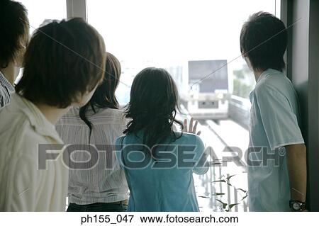 Stock Photo - Rear view of five friends looking at a train. Fotosearch