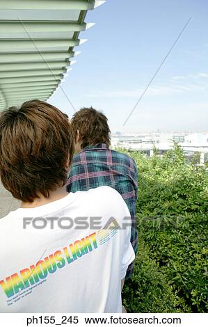 Rear view of two men in a balcony View Large Photo Image Stock Photography - Rear view of two men in a balcony. Fotosearch