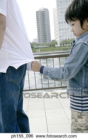 Side profile of a boy pulling another person's t-shirt View Large Photo Image Stock Photograph - Side profile of a boy pulling another person's t-shirt. Fotosearch