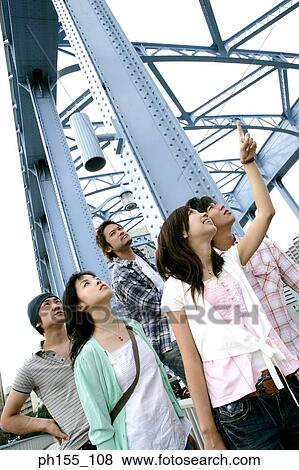 Three young men and two young women standing together and looking up View Large Photo Image Stock Photo - Three young men and two young women standing together and looking up. Fotosearch
