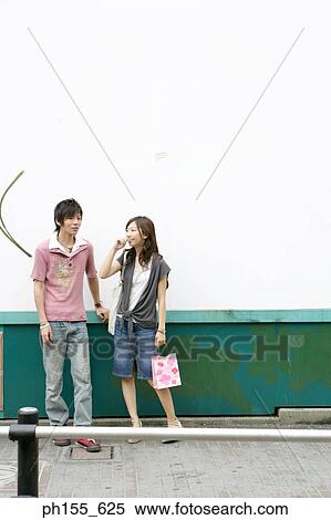 Young couple standing together and smiling View Large Photo Image Stock Photography - Young couple standing together and smiling. Fotosearch