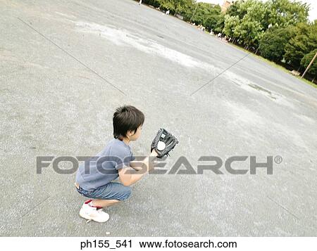 High angle view of a boy sitting and holding a baseball View Large Photo Image Stock Image - High angle view of a boy sitting and holding a baseball. Fotosearch