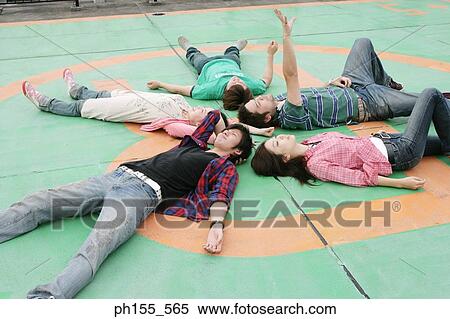High angle view of two young women and three young men lying on the floor View Large Photo Image Stock Photography - High angle view of two young women and three young men lying on the floor. Fotosearch