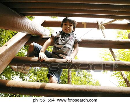 Low angle view of a boy playing on a jungle gym View Large Photo Image Picture - Low angle view of a boy playing on a jungle gym. Fotosearch