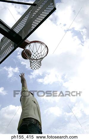 Low angle view of a man playing basketball View Large Photo Image Stock Photography - Low angle view of a man playing basketball. Fotosearch