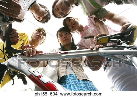 Picture - Low angle view of two young women and three young men with a bicycle. Fotosearch