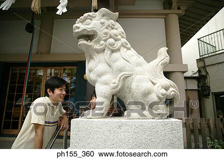Mid adult man and his son standing near a statue View Large Photo Image Stock Image - Mid adult man and his son standing near a statue. Fotosearch