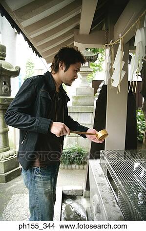 Side profile of a young man holding a ladle View Large Photo Image Picture - Side profile of a young man holding a ladle. Fotosearch