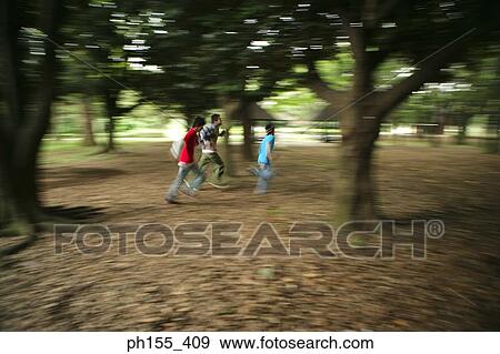Stock Photo - Three men playing in a park. Fotosearch
