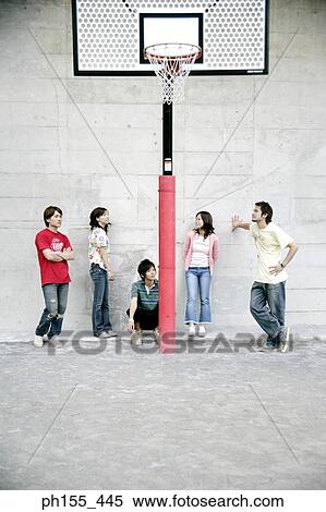 Stock Photography - Three young men and two young women near a basketball hoop. Fotosearch