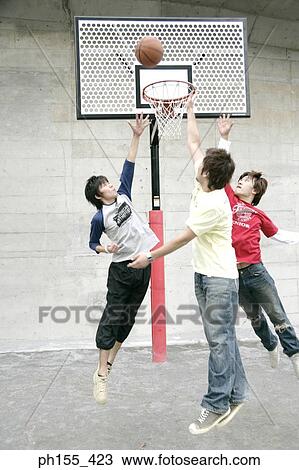 Three young men playing basketball View Large Photo Image Stock Image - Three young men playing basketball. Fotosearch