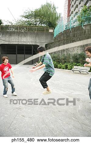 Three young men playing jump rope View Large Photo Image Stock Image - Three young men playing jump rope. Fotosearch